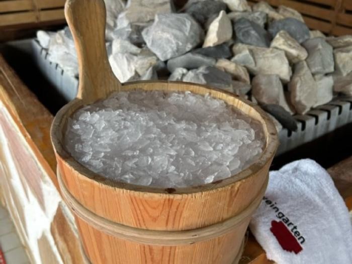 Ein Holzeimer mit Eiswürfeln steht in der Sauna