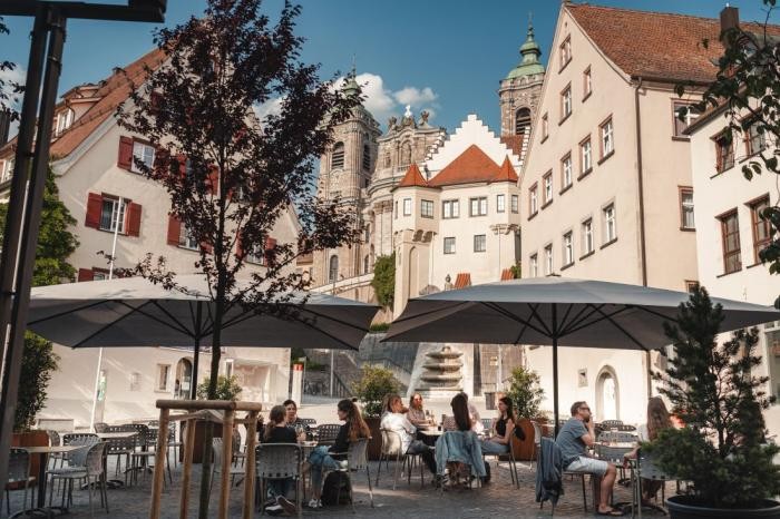 Café auf dem Münsterplatz  Ein gut besuchtes Café auf dem Münsterplatz, im Hintergrund die Basilika