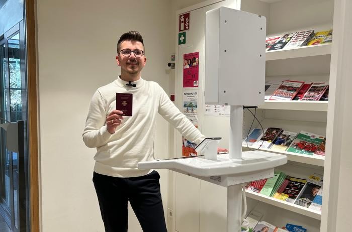 Eien Frau steht im Amtshaus an einem Terminal, um ein biometrisches Porträtfoto von sich machen zu lassen.