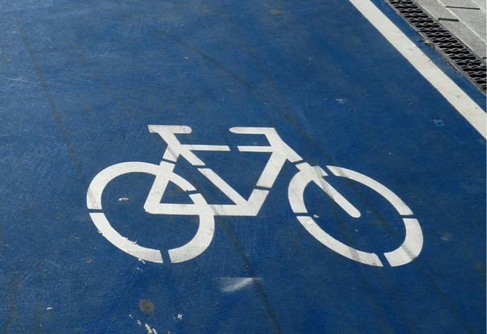 Blaue Radwegmarkierung mit weißem Fahrrad