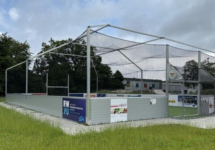 Blick auf den Kick-Käfig, ein umzäuntes Minispielfeld mit zwei Toren zum Fußballspielen. 