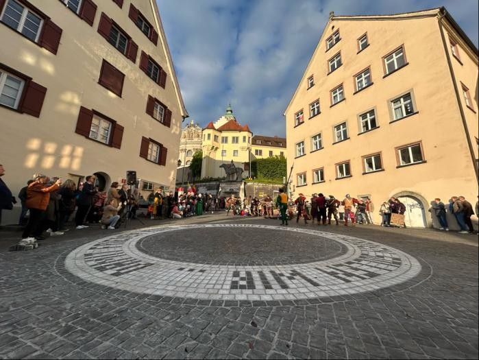 Eine in den Boden eingelassene, kreisrunde Schrift auf dem Münsterplatz