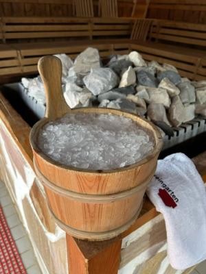 Ein Holzeimer mit Eiswürfeln steht in der Sauna