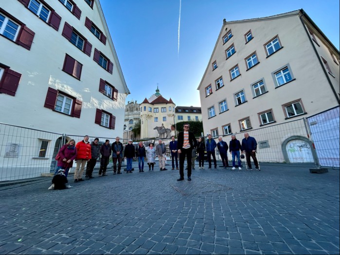 Eine Gruppe Personen steht auf dem Münsterplatz genau an der Stelle, an der in den nächsten Wochen ein Denkmal in die Pflastersteine gesetzt wird