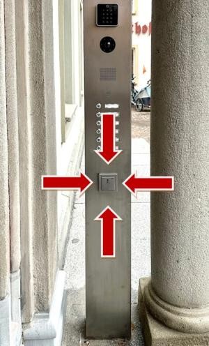 Vier Pfeile zeigen auf einen Schalter an einer Säule