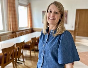 Das Porträt einer Frau in einem großen Raum mit Tischen und Stühlen