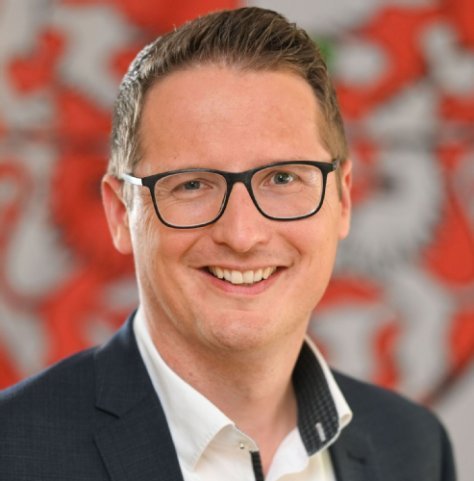 Fachbereichsleiter Florian Keller mit Flagge von Weingarten als Hintergrund